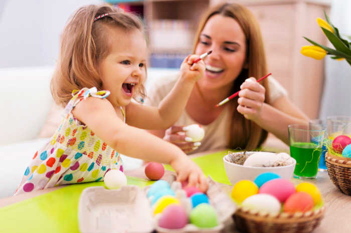 Mother and child dying eggs. 