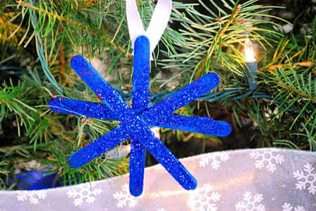 Glitter snowflake hanging on tree. 