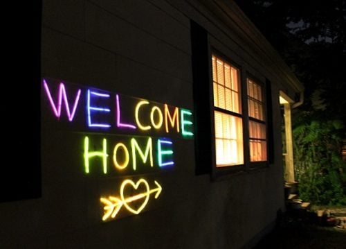 Glow in the dark sign on the outside of house. 