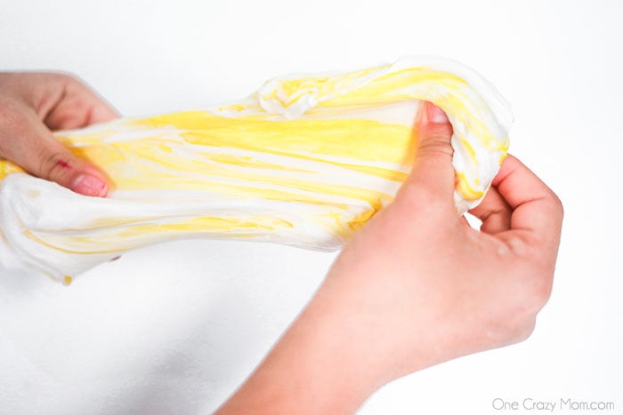 Butter slime stretched with a hand. 