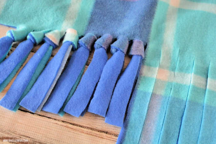 Lær hvordan du gjør en fleece tie teppe for den perfekte ettermiddag DIY aktivitet. Dette no sew fleece teppet er så lett å lage og perfekt for gave å gi.