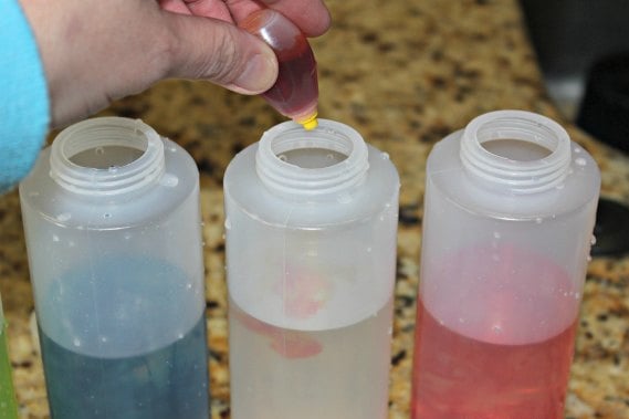 Adding food coloring to each bottle.